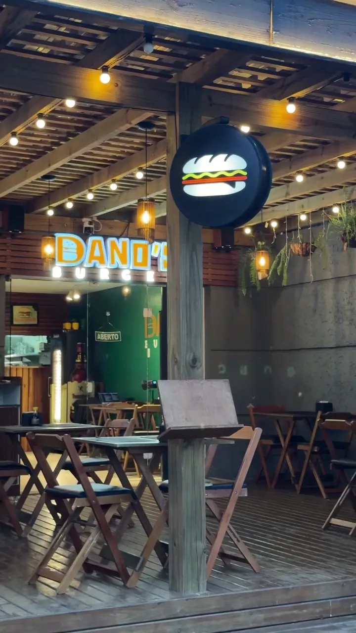 Deck de Dano's Burger en Canasvieiras, con el cartel iluminado y las mesas al aire libre